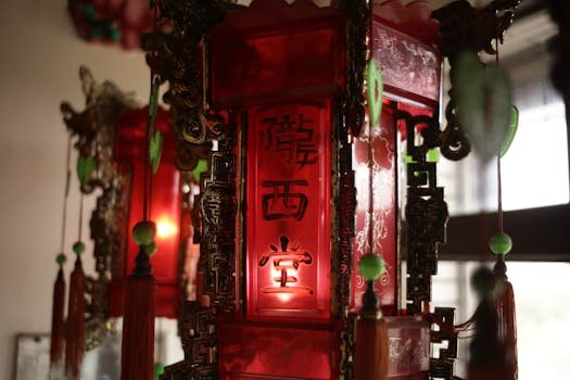 Close-up of a red lantern with ornate carvings and Chinese characters, indoors.