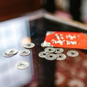 A table with traditional Chinese coins and a red envelope, symbolizing prosperity and luck.