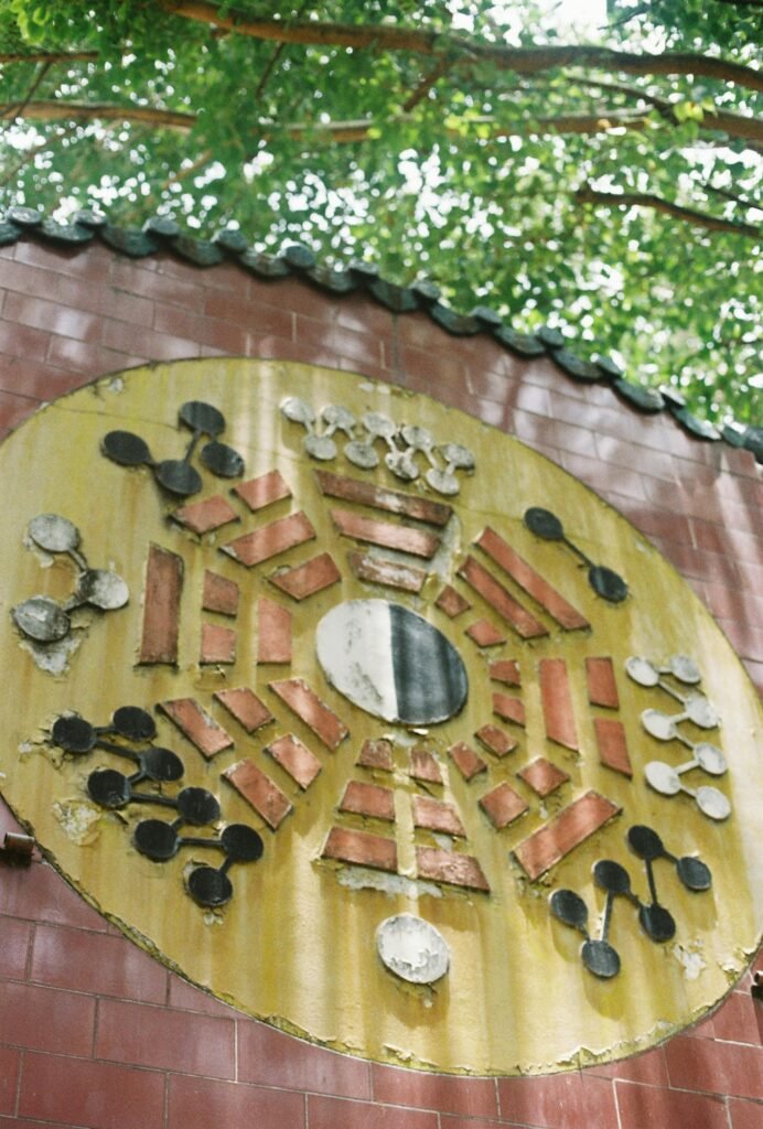 Intricate feng shui wall art in Ho Chi Minh City under lush greenery.