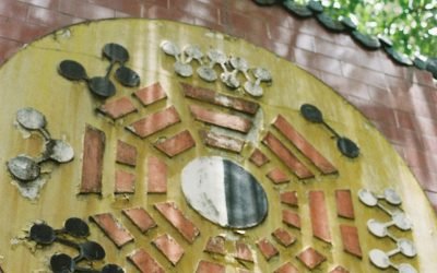 Intricate feng shui wall art in Ho Chi Minh City under lush greenery.